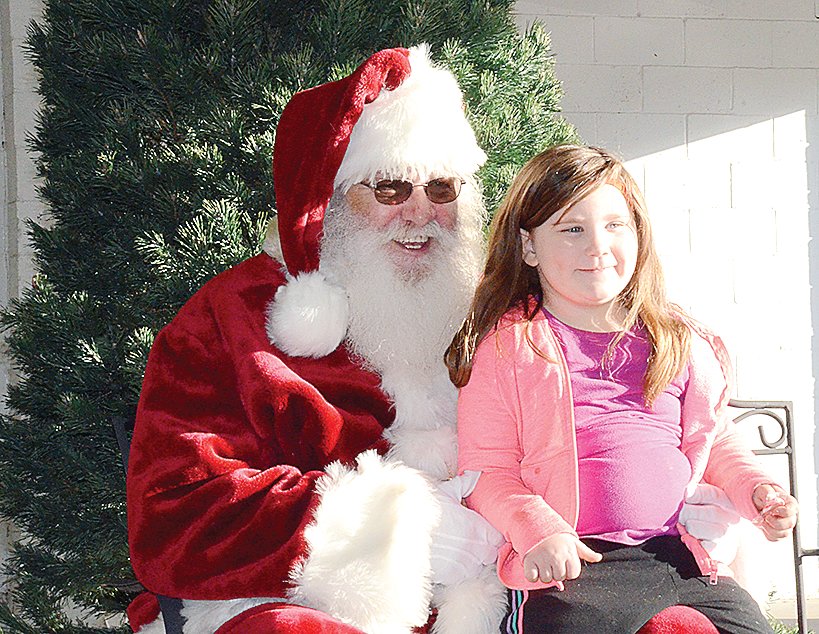 Five-year-old Giana Hayes of Farmersville took a few moments to tell Santa what she wants for Christmas this year in downtown Farmersville on Saturday, Nov. 27.
